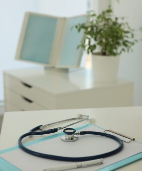 Doctor's workplace with stethoscope and clipboard in office
